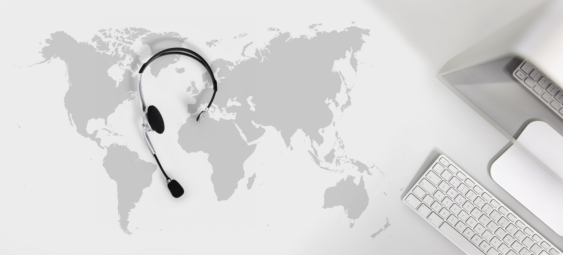 A world map, headset, keyboard and mouse pad
